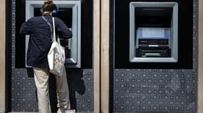 Une femme retire de l'argent à un distributeur automatique bancaire, le 3 juin 2025 à Paris
