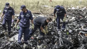 Des agents des secours d'urgence ukrainiens à la recherche des corps sur le site du crash du vol MH17, le 20 juillet dernier.
