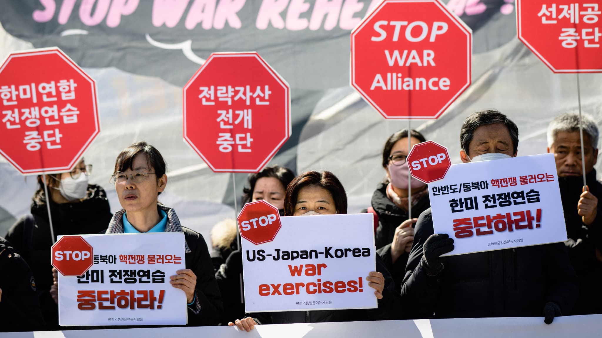 Des militants brandissent des pancartes lors d'un rassemblement à Séoul le 13 mars 2023 contre "Freedom Shield", les plus grands exercices militaires entre les États-Unis et la Corée du Sud depuis cinq ans.