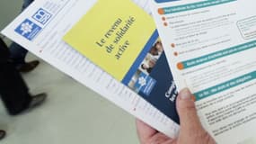 Une personne présente les brochures informant sur le RSA , quelques jours après son entrée en vigueur, le 4 juin 2009 à Paris.