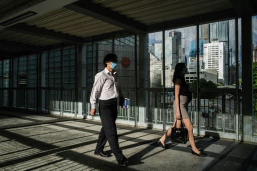 Des habitants de Hong Kong empruntent le 3 juin 2020 une passerelle recouverte de grillage, édifiée par les autorités locales en réponse aux manifestations pro-démocratie. Des habitants de Hong Kong empruntent le 3 juin 2020 une passerelle recouverte de grillage, édifiée par les autorités locales en réponse aux manifestations pro-démocratie.