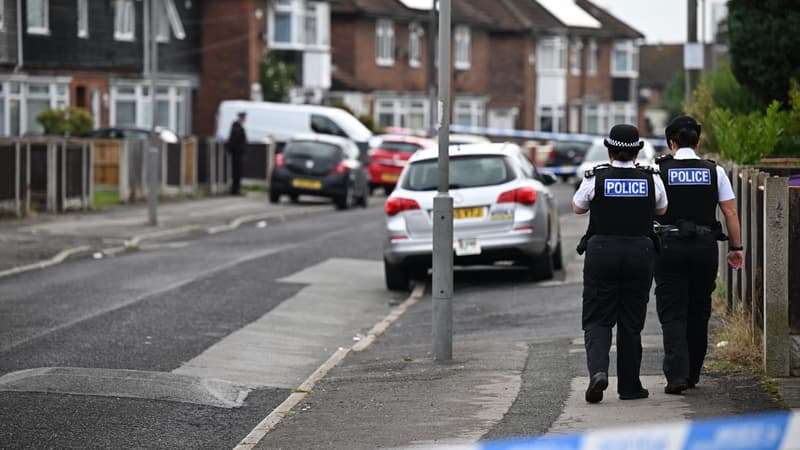 Deux policiers britanniques passent devant la maison de la famille d'Olivia Pratt-Korbel, tuée chez elle par balle, à Liverpool, au Royaume-Uni, le 23 août 2022