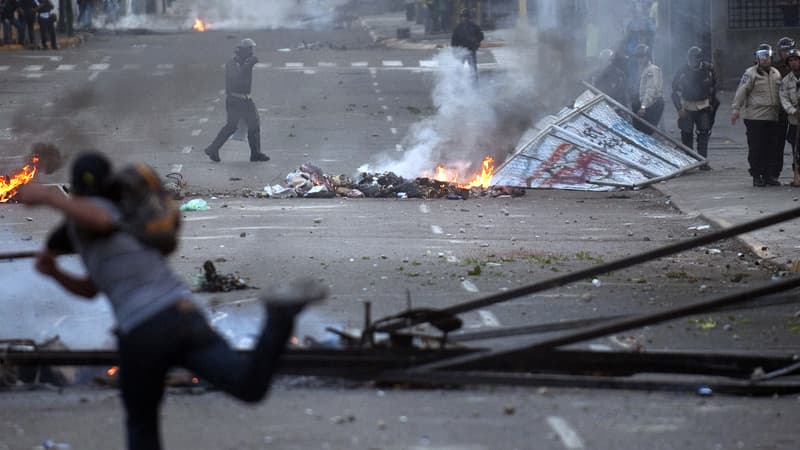 Un manifestant affronte des policiers antiémeutes le 22 février, à Caracas.