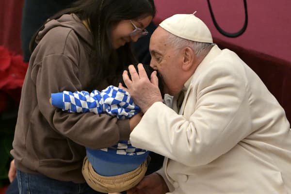 Le pape François embrasse un enfant du dispensaire médical Sainte-Marie au Vatican, le 17 décembre 2023