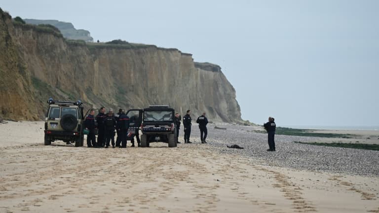 Des policiers près d'un corps découvert sur la plage de Sangatte, près de Calais, d'où de nombreux migrants tentent la traversée de la Manche, le 2 novembre 2024 dans le Pas-de-Calais