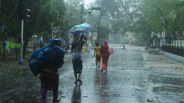 Des résidents marchent jusqu'à un abri avant l'arrivée prévue du cyclone Amphan à Digha, au Bengale occidental, le 20 mai 2020. 