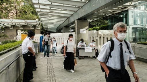 Des habitants de Hong Kong déambulent le 3 juin 2020 près de barricades dressées par les autorités locales en réponse aux manifestations pro-démocratie.