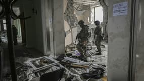 Des militaires ukrainiens dans un bâtiment en ruines à Kharkiv (est de l'Ukraine), le 27 mars 2022