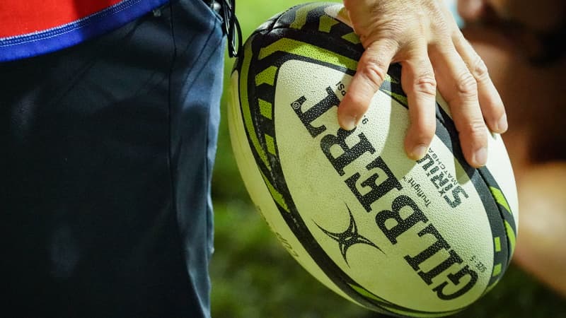 Un ballon de rugby tenu à la mail