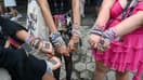 Des fans de Taylor Swift présentent leurs "bracelets d'amitié" et le nombre 13 (porte-bonheur de la star) au "Eras Tour", à Singapour, le 2 mars 2024