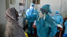 Un agent de santé effectue un prélèvement sur une femme en vue d'un test de Covid-19 à Siliguri (Inde) le 29 août 2020