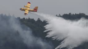 Un avion lâchant de l'eau au-dessus de l'incendie
