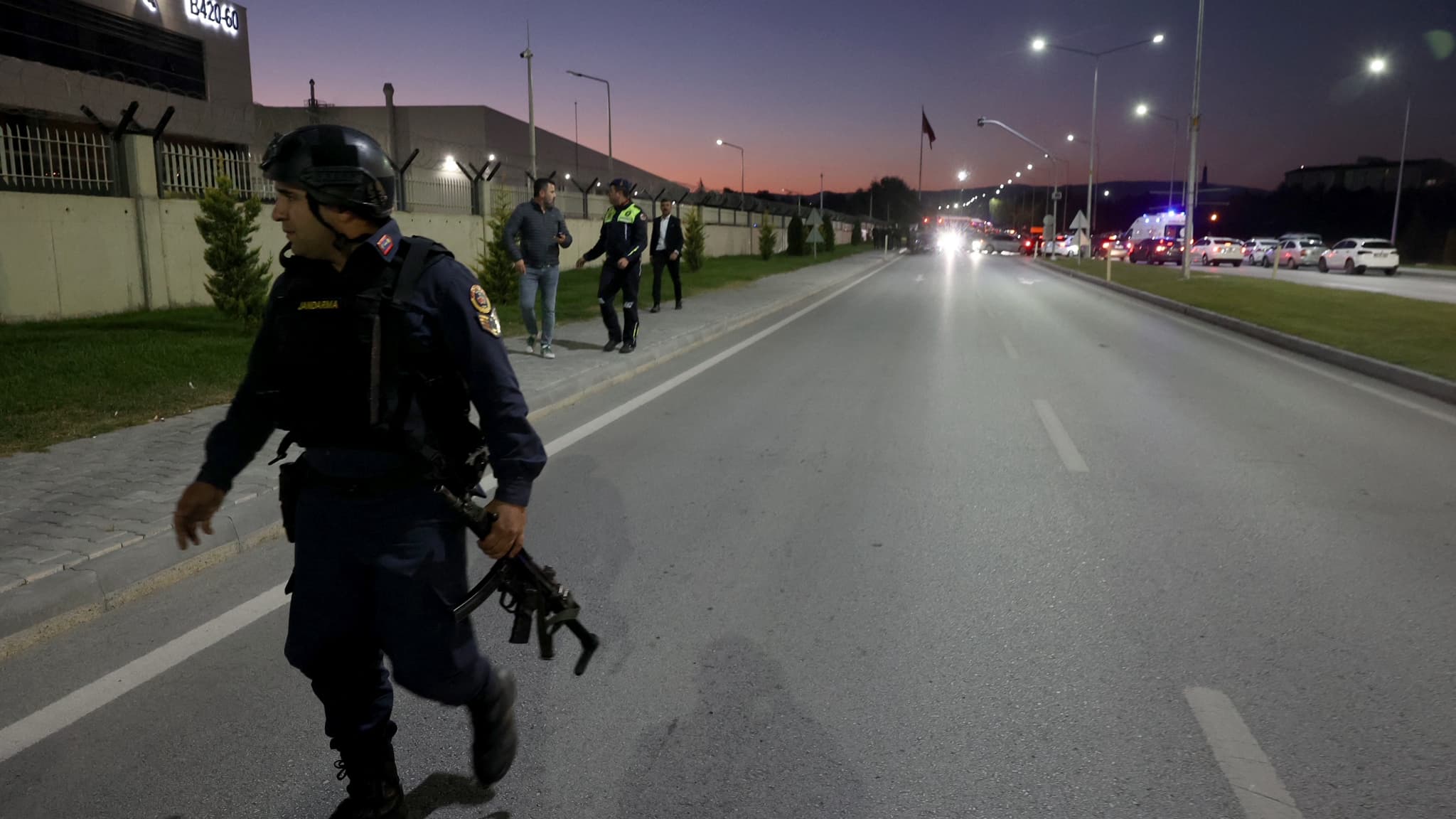 Un policier armé marche sur la route principale menant au bâtiment des Industries aérospatiales turques, après une explosion à leur siège, à Kahramankazan, en Turquie, le 23 octobre 2024.