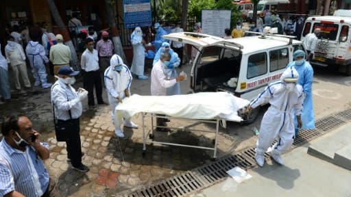 Le corps d'une victime du coronavirus est sorti d'une ambulance pour être incinéré au crématorium du site de Nigambodh Ghat, le 3 juin 2020 à New Delhi Le corps d'une victime du coronavirus est sorti d'une ambulance pour être incinéré au crématorium du site de Nigambodh Ghat, le 3 juin 2020 à New Delhi