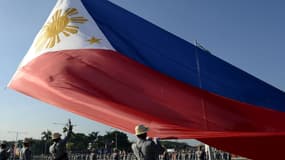 Les gardes d'honneur philippins hissent un drapeau géant pendant le 119e anniversaire de la mort du héros national José Rizal au parc Luneta, à Manille le 30 décembre 2015.