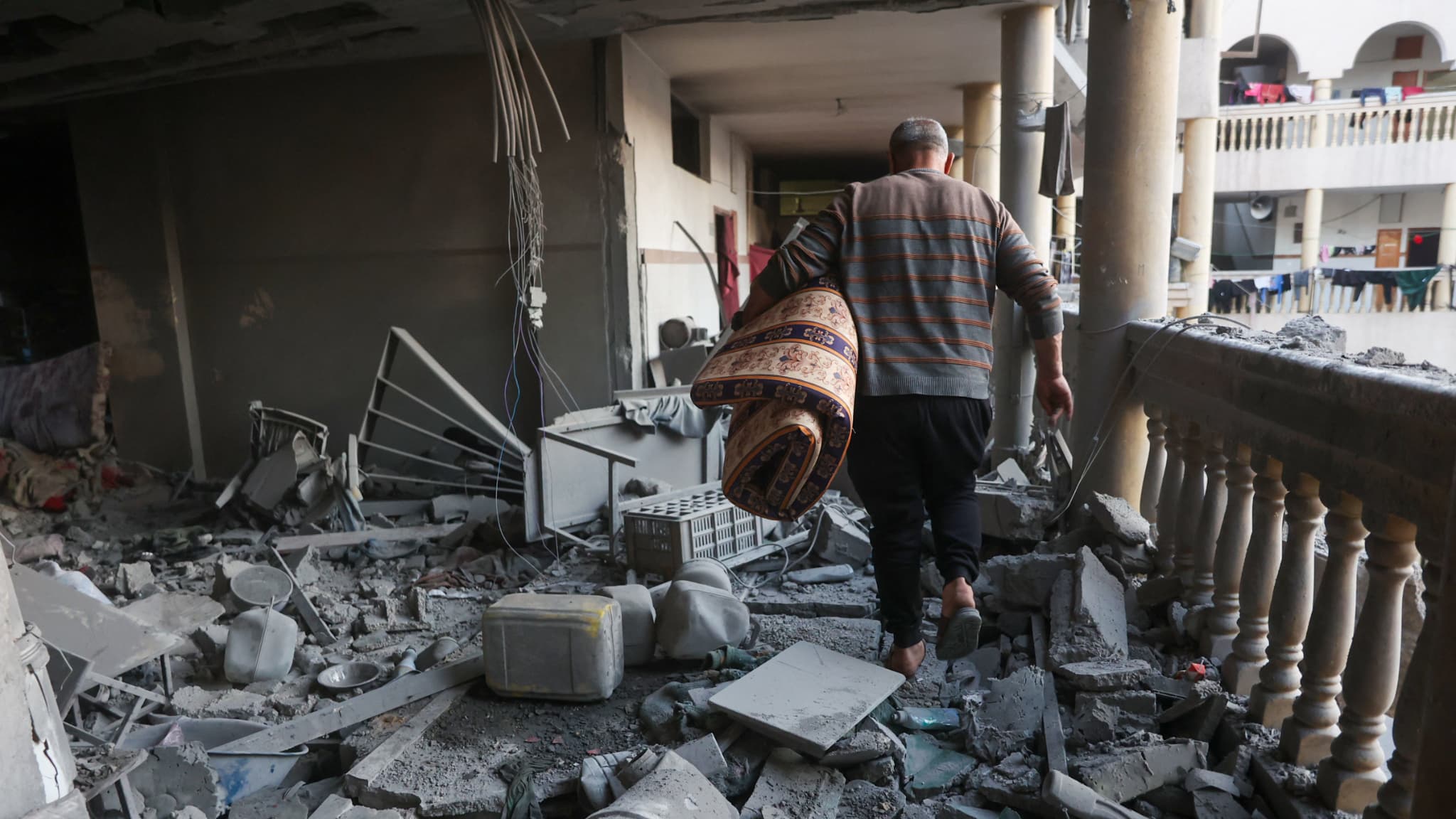 Un homme marche dans les décombres d'une école détruite par les bombardements israéliens à Gaza le 18 mars 2025.