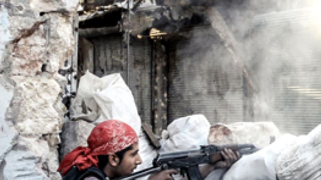 Un rebelle syrien en plein échange de tirs, en Syrie.
