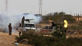 Des combattants insurgés à la poursuite de forces loyales à Mouammar Kadhafi, sur la route à 120 km à l'est de Syrte. La ville, dont le dirigeant libyen a fait sa deuxième capitale, attend l'assaut des rebelles qui progressent dans sa direction. /Photo pr
