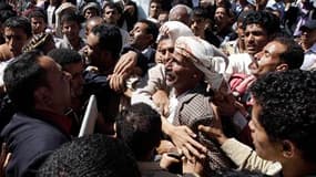 Des manifestants de l'opposition entourent un homme soutenant le président yéménite Ali Abdallah Saleh, dimanche à Sanaa. Des partisans du régime ont tenté dimanche de s'opposer à une manifestation de l'opposition dans la capitale du Yémen et des coups de