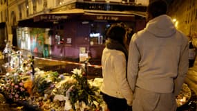 Un couple se recueille, le 20 novembre 2015, devant la façade du restaurant La Casa Nostra, rue de la Fontaine au Roi (XIe arrondissement de Paris), où cinq personnes ont été abattues lors des attentats de Paris.
