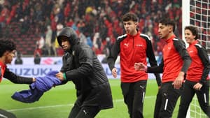 Un gardien de but portant le maillot du PSG en train de défendre un penalty.