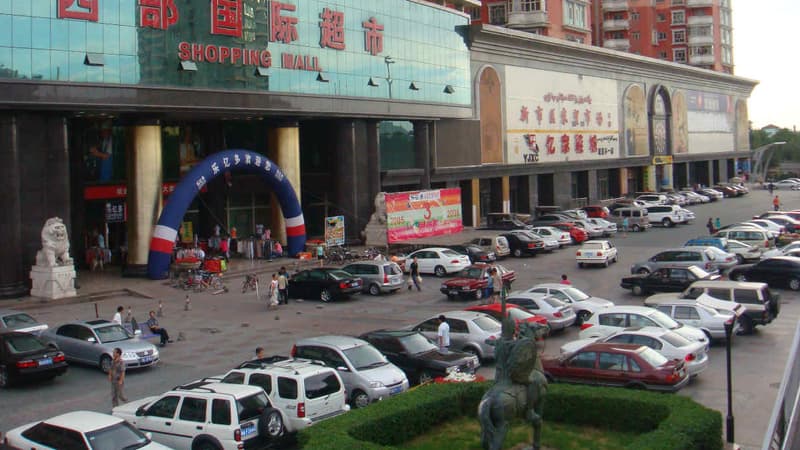 Des voitures stationnées devant un centre commercial à Urumqi, capitale du Xinjiang.