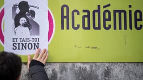 Un manifestant colle une affiche contre la réforme du BAC, à Nantes, lors de la grève du 14 février. 