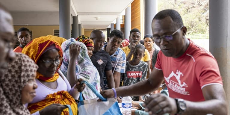 Des habitants de Mayotte font la queue pour recevoir de la nourriture et de l'eau lors d'une distribution à Mtsahara, le 25 décembre 2024.