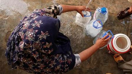 Une femme remplit des bouteilles avec de l'eau potable, dans un hôpital de campagne, à Nowshera, dans le nord-ouest du Pakistan. Les inondations provoquées dans le pays par des pluies de mousson diluviennes ont fait plus de 1.600 morts, 2 millions de sans