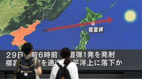 Des passants à Tokyo devant un écran montrant la trajectoire du missile au-dessus du Japon le 29 août 2017