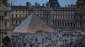 Des touristes se pressent autour de la Pyramide du Louvre, dessinée par l'architecte sino-américain Ieoh Ming Pei, à Paris, le 8 août 2024