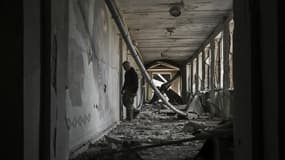 Un résident marche à l'intérieur d'une école détruite après une attaque à Chasiv Yar, à l'ouest de Bakhmout, le 22 mars 2023.