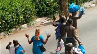 Des civils lèvent les bras en passant devant les soldats fidèles à Laurent Gbagbo, à Abidjan. Paris a décidé dimanche de regrouper tous les Français d'Abidjan pour assurer leur protection et réfléchit à un possible rapatriement de ses 12.000 ressortissant