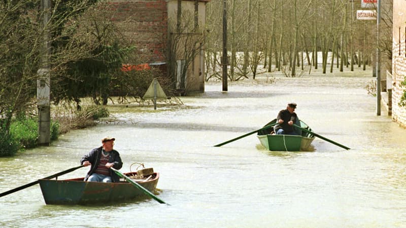 Deux hommes se déplacent en barque, le 22 mars 2001 dans les rues inondées du village de Saunières