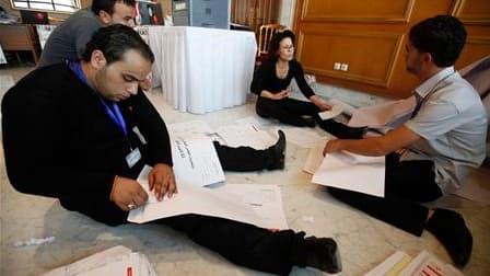 A Tunis, des employés de la Commission électorale recensent les résultats des élections constituantes de dimanche. Les islamistes modérés d'Ennahda annoncent avoir remporté plus de 30% des voix dépouillées jusqu'ici, se fondant sur les résultats affichés