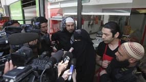 Le gouvernement français va étudier une éventuelle déchéance de nationalité d'un homme soupçonné de polygamie (à gauche, ici lors de la conférence de presse à Nantes après l'amende reçue par son épouse pour conduite avec un niqab) et de fraudes aux aides