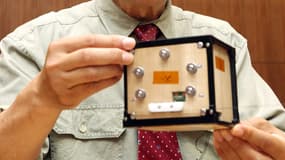 Takao Doi, astronaute et professeur spécial à l’Université de Kyoto, tient le premier satellite en bois au monde fabriqué à partir de bois et nommé LignoSat lors d’une conférence de presse sur le campus de l’université à Kyoto le 28 mai 2024.