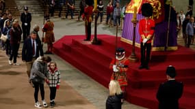 Des Britanniques se recueillent devant le cercueil de la reine Elizabeth II. 