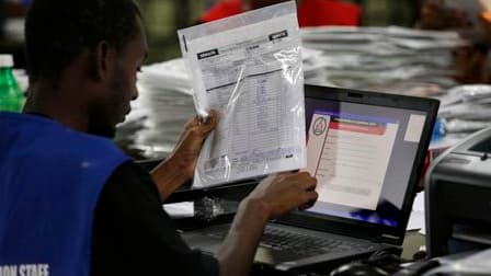Un agent entre des données dans une base informatique au centre de traitement des résultats électoraux, à Port-au-Prince. En dépit d'"irrégularités", les observateurs internationaux ont prudemment cautionné les élections de dimanche en Haïti. /Photo prise