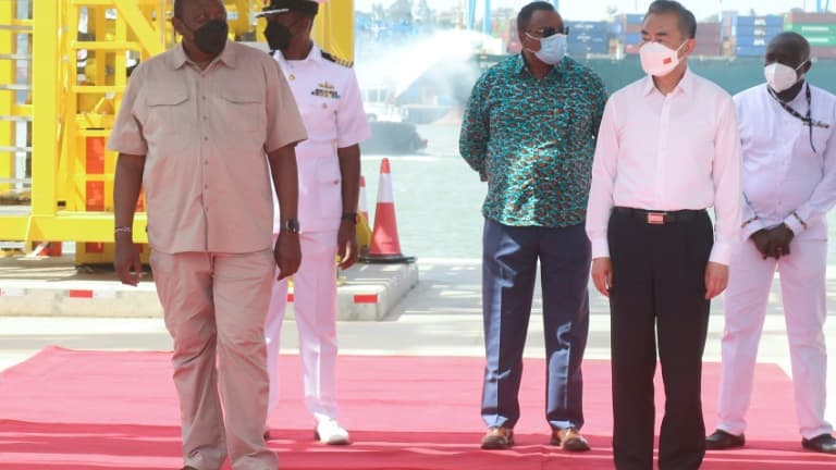 Le président kényan Uhuru Kenyatta (G) et le ministre chinois des Affaires étrangères Wang Yi (D) visitent le 6 janvier 2022 un nouveau terminal portuaire à Mombasa, au Kenya, financé par la Chine