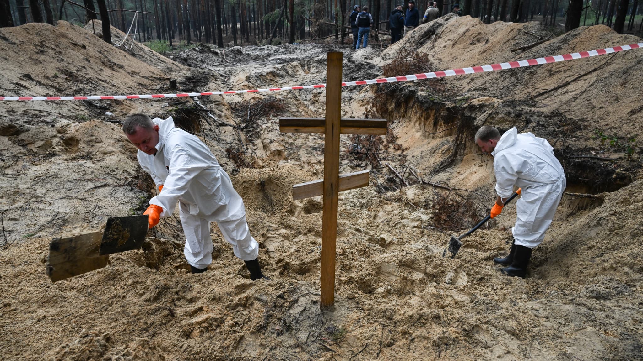 Deux techniciens médico-légaux creusent près d'une croix dans une forêt à la périphérie d'Izyum, dans l'est de l'Ukraine, le 16 septembre 2022.
Deux techniciens médico-légaux creusent près d'une croix dans une forêt à la périphérie d'Izyum, dans l'est de l'Ukraine, le 16 septembre 2022.