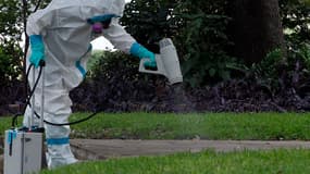 Un homme désinfecte la pelouse, devant la maison où réside une soignante contaminée par Ebola, à Dallas, au Texas, le 12 octobre 2014.