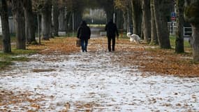 Deux personnes marchent dans une allée de Soisy-sur-Seine,près de Paris, le 14 décembre 2022