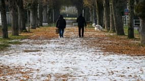 Deux personnes marchent dans une allée de Soisy-sur-Seine,près de Paris, le 14 décembre 2022