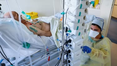 Une soignante s'occupe d'un patient atteint du Covid-19 dans l'unité de soins intensifs de l'hôpital privé l'Estrée, le 12 novembre 2020 à Stains, près de Paris
