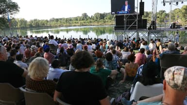 Des spectateurs se rassemblent pour regarder Jean-Luc Mélenchon, fondateur du parti de gauche La France Insoumise (LFI), s'afficher sur un écran lors de son discours à l'"Amfis 2024", à Châteauneuf-sur-Isère, dans le sud-est de la France, le 23 août 2024.