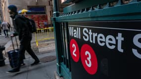 Des gens marchent le long de Wall Street près de la Bourse de New York le 11 mars 2025 à New York.