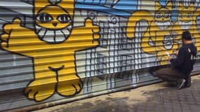 L'artiste peint des chats jaunes sur les murs des villes du monde entier depuis 2007.