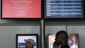 Des passagers consultent le tableau d'affichage des départs à l'aéroport Roissy Charles-de-Gaulle, près de Paris, pendant la grève des contrôleurs aériens français, le 3 juillet 2025. Photo d'illustration