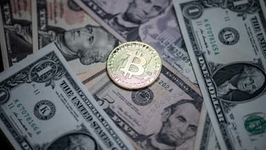 Une monnaie cryptographique (Bitcoin) cohabite avec des coupures en dollars dans un bureau de change à Paris, le 26 avril 2021 